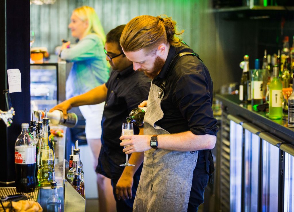 barman pours prosecco